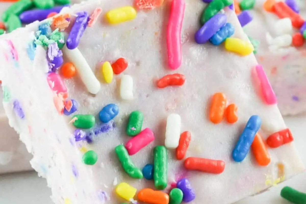 A close up of a piece of fudge with sprinkles on it, made from a delicious white chocolate recipe.