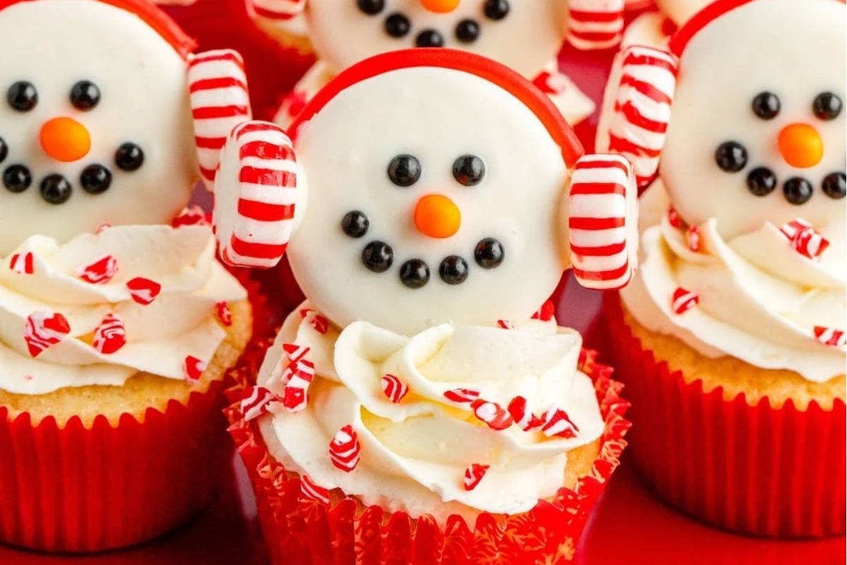 Cute cupcakes decorated with snowmen and candy canes.
