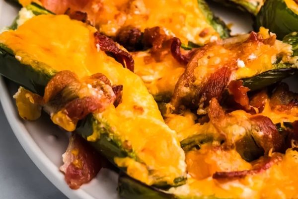 Stuffed jalapenos with bacon and cheese on a plate.