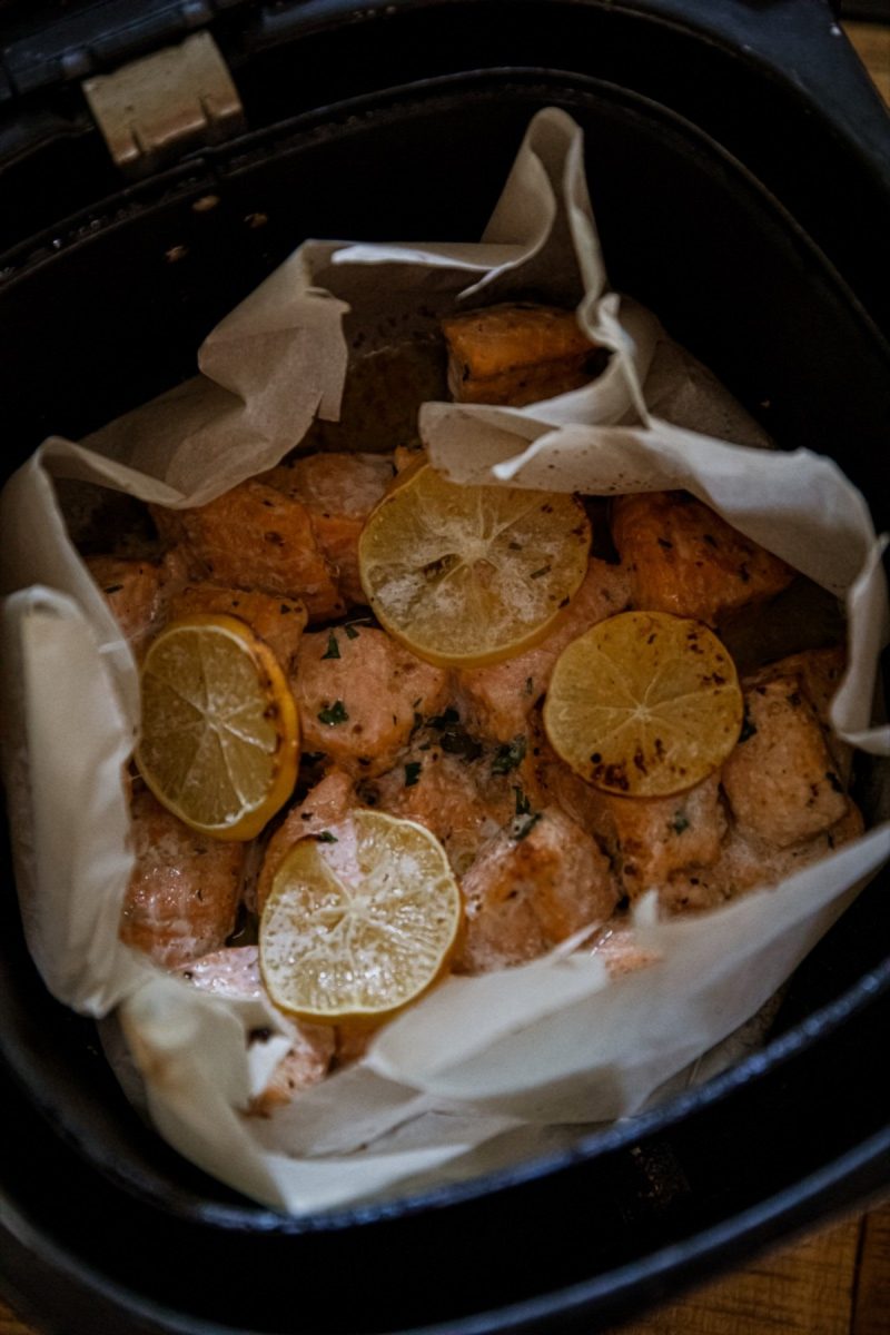 Air fryer salmon fillets with lemon slices.