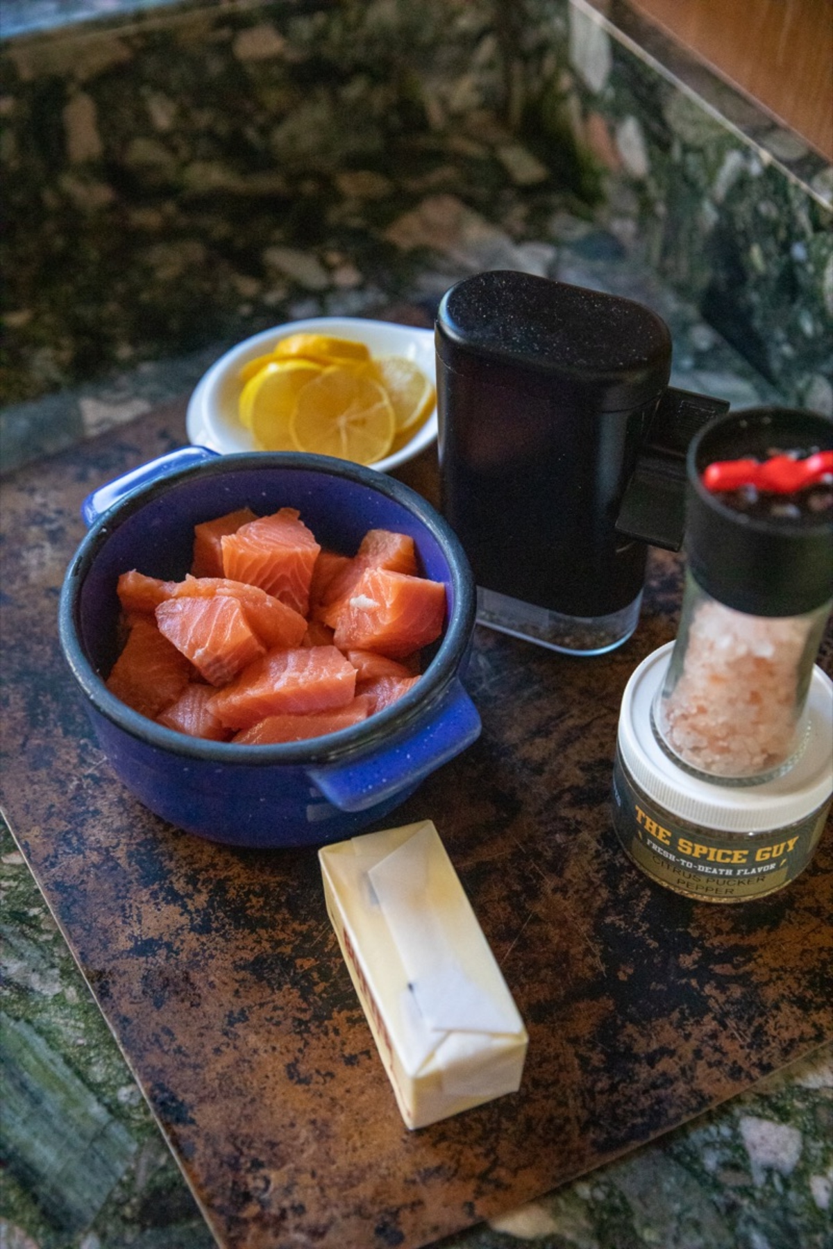 Air fryer salmon bites topped with lemon and a pinch of salt displayed on a counter.