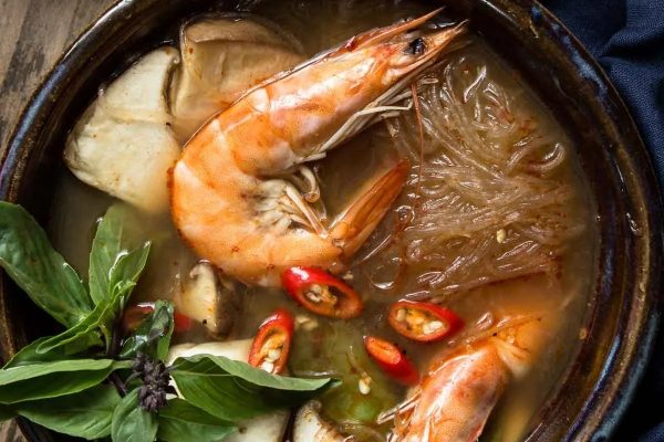 A delicious Asian seafood recipe consisting of a bowl of soup filled with succulent shrimp and nutritious vegetables.