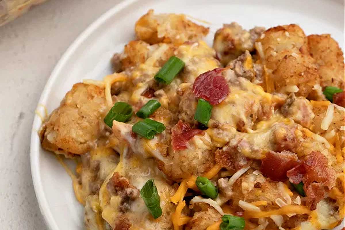 Cheesy tater tot casserole on a white plate.