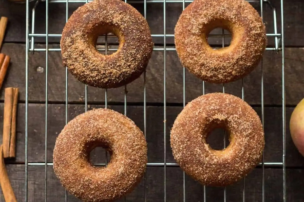 Apple cider cinnamon donuts on a cooling rack.