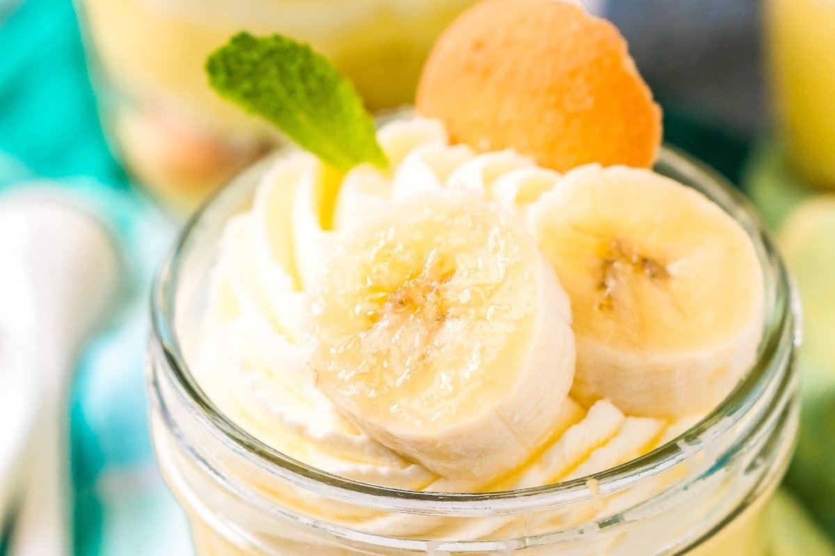 Trifles: Banana pudding in a jar with whipped cream and banana slices layered beautifully for a delightful treat.