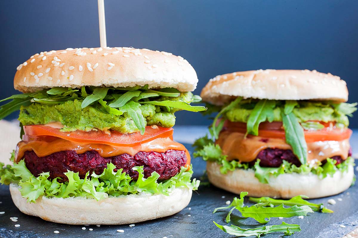 Two beet burgers with guacamole and lettuce.