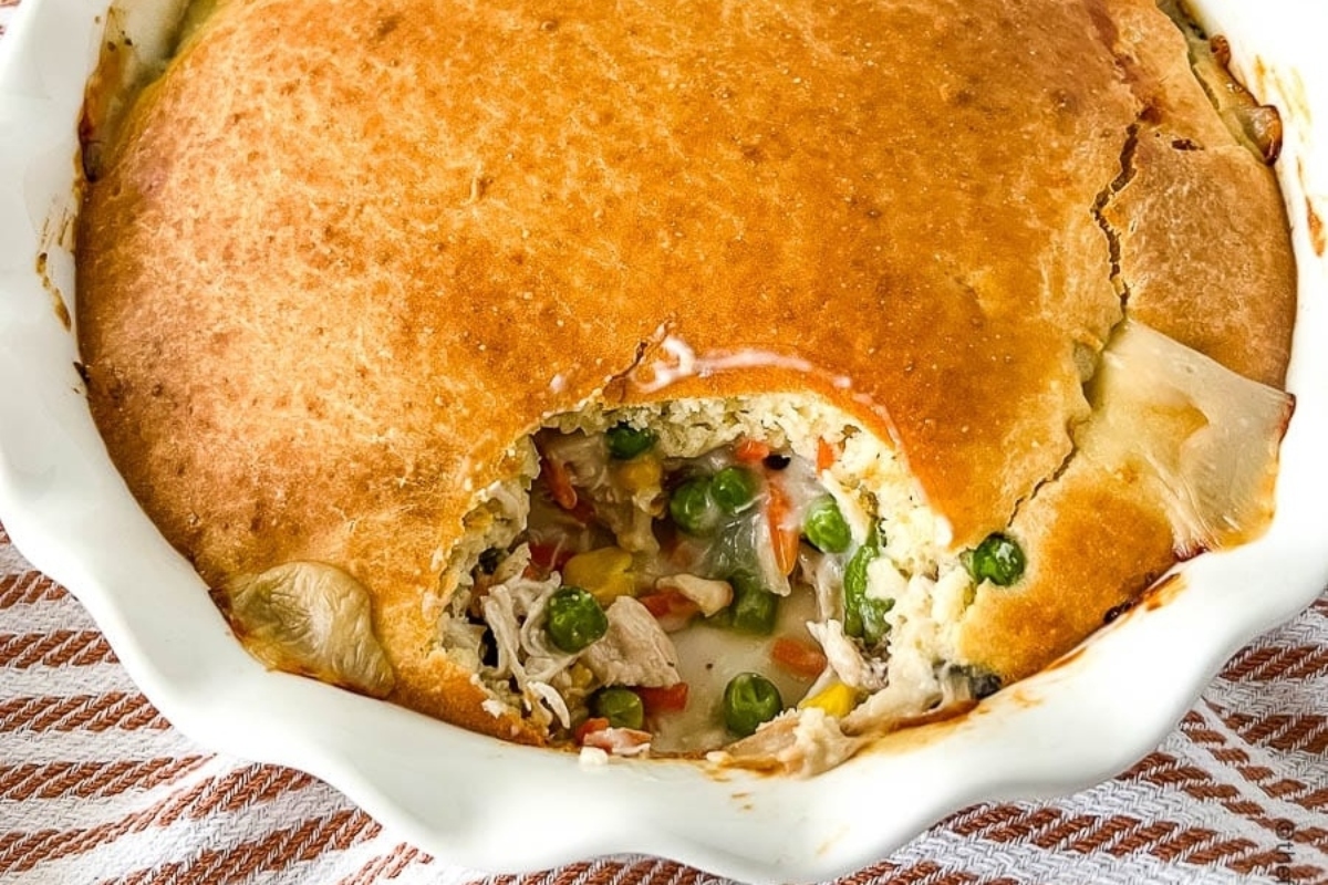 Chicken pot pie with frozen mixed vegetables in a white dish.