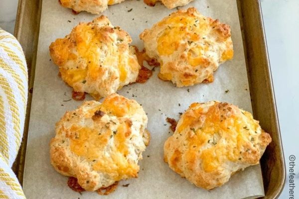 Cheesy biscuits on a baking sheet.