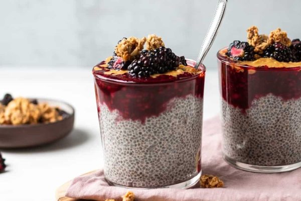 A bowl of chia pudding topped with blackberries and granola, perfect for a delicious breakfast or convenient meal prep option.