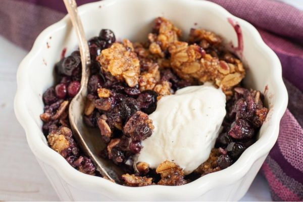Blueberry crisp with ice cream in a bowl.