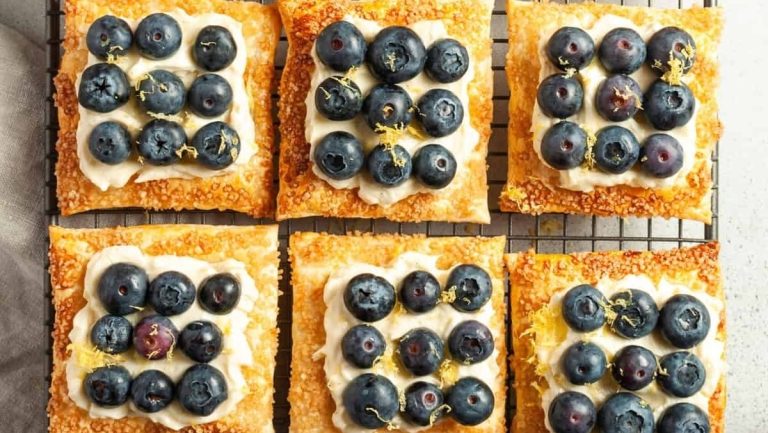 Blueberry and lemon tarts on a cooling rack.