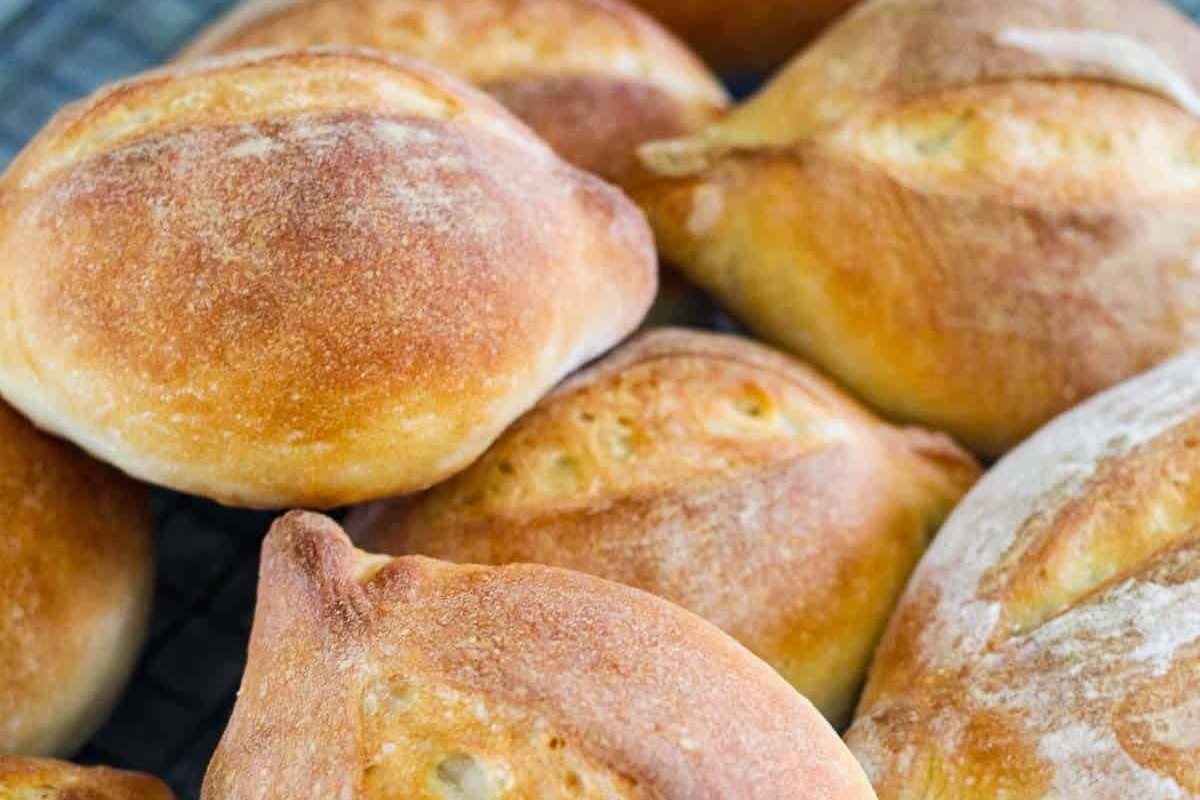 A stack of bread rolls on a cooling rack, perfect for recipes or filling up a bread basket.