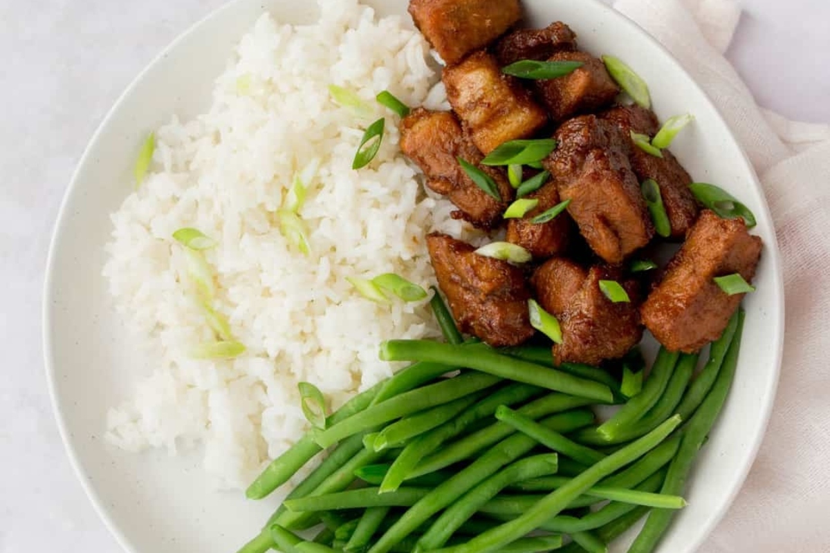 A white plate with green beans and tofu on it, perfect for vegetarian dinners.