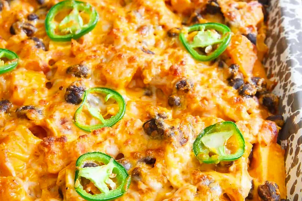 Cheesy sweet potato casserole in a baking dish with jalapenos.
