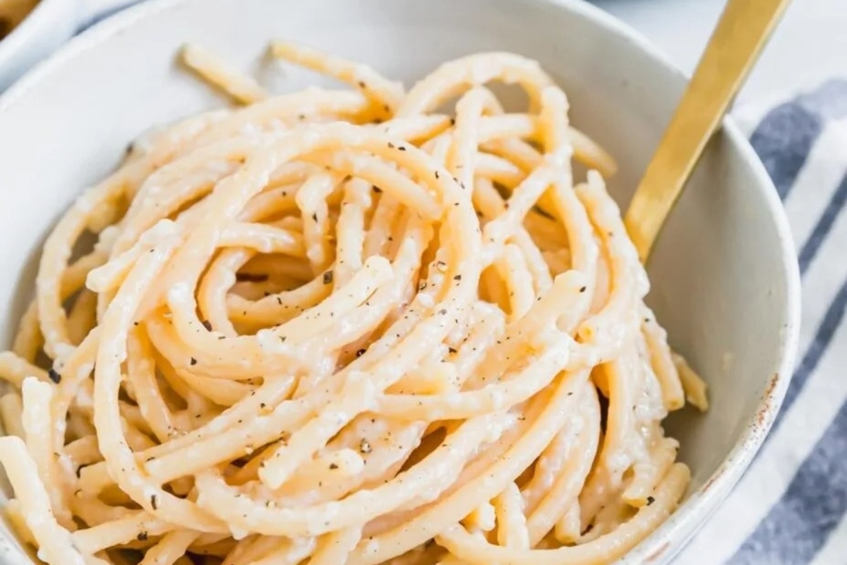 An exquisite Italian main dish - a bowl of pasta adorned with a gold fork.