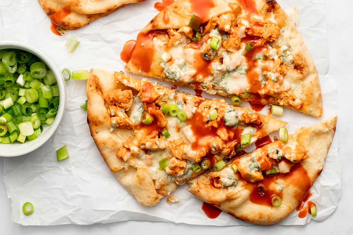 Bbq chicken pizza with ketchup and green onions.