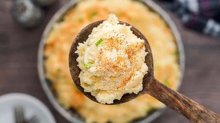 Potato salad being scooped by a spoon.