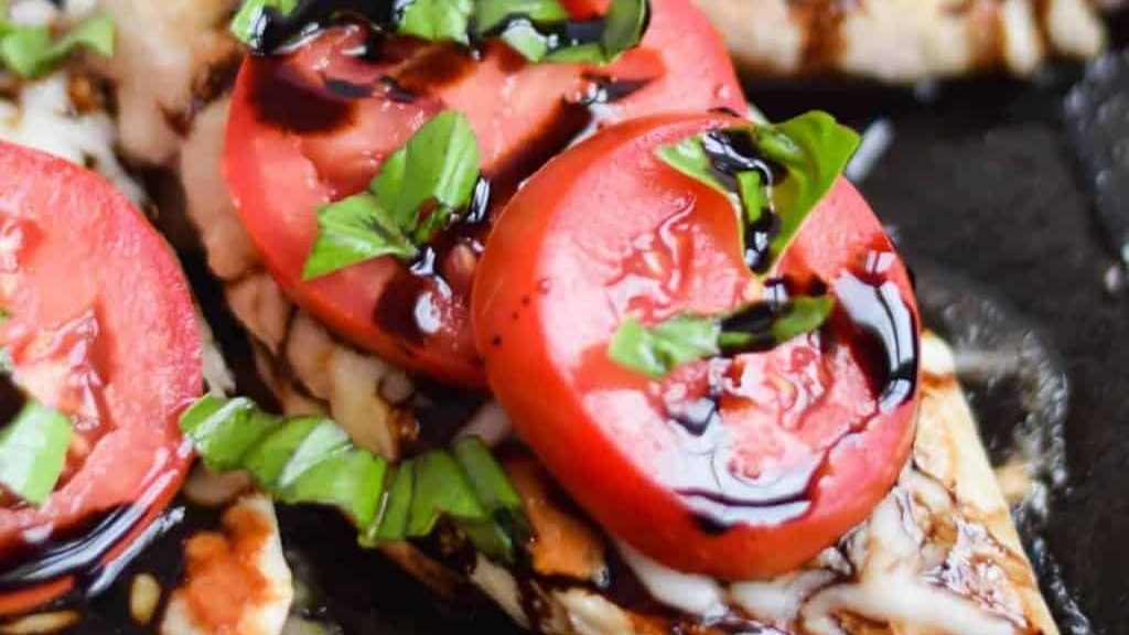 Grilled chicken breasts with tomatoes and basil.