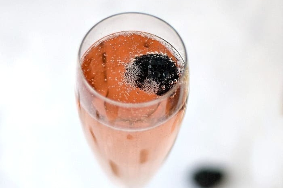 A sparkling glass of champagne with succulent blackberries, perfect for champagne cocktails.