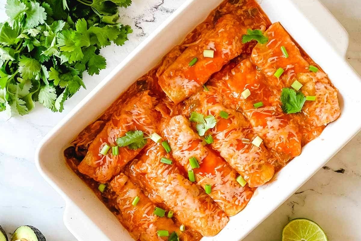 Comforting Mexican enchiladas in a white baking dish.