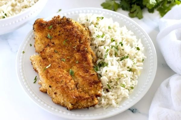 A plate with chicken and rice on it.