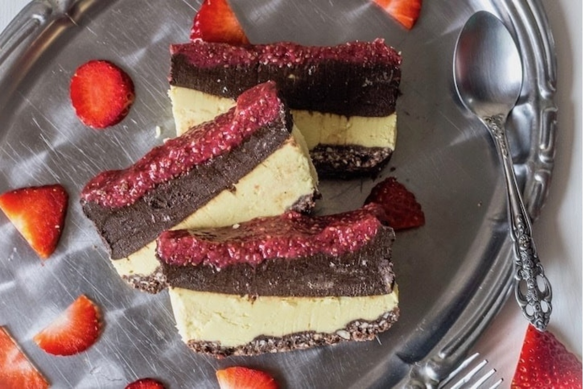 A plate of chocolate and strawberry cheesecakes, perfect for indulging during the Christmas season, on a silver plate.
