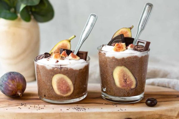 Two glasses of chocolate pudding with figs and whipped cream, perfect for a delicious breakfast or meal prep.