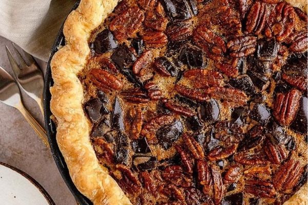 Chocolate pecan pie on a plate with a fork.