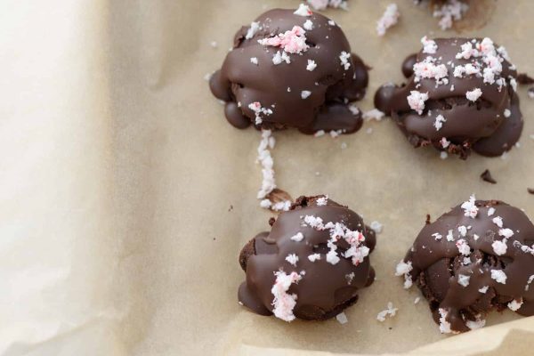 Chocolate covered peppermint truffles on a baking sheet.