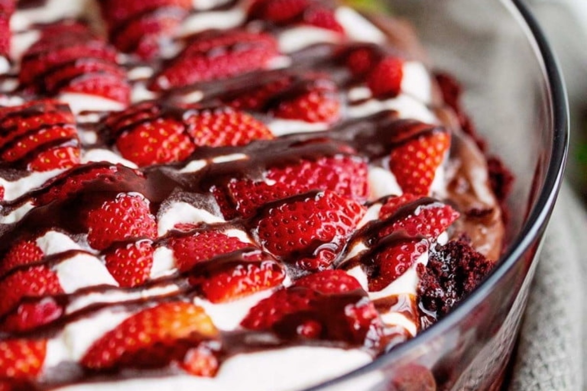 A Trifle dish with strawberries and whipped cream.