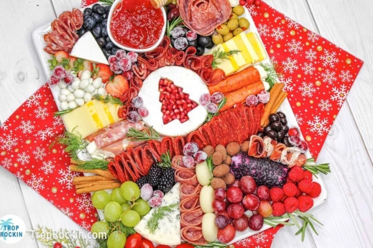 A festive Christmas platter featuring an assortment of appetizers including meats and cheeses.