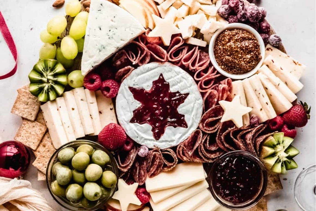 A festive platter of Christmas-inspired cheese, fruit, and nut combinations elegantly arranged on charcuterie boards.