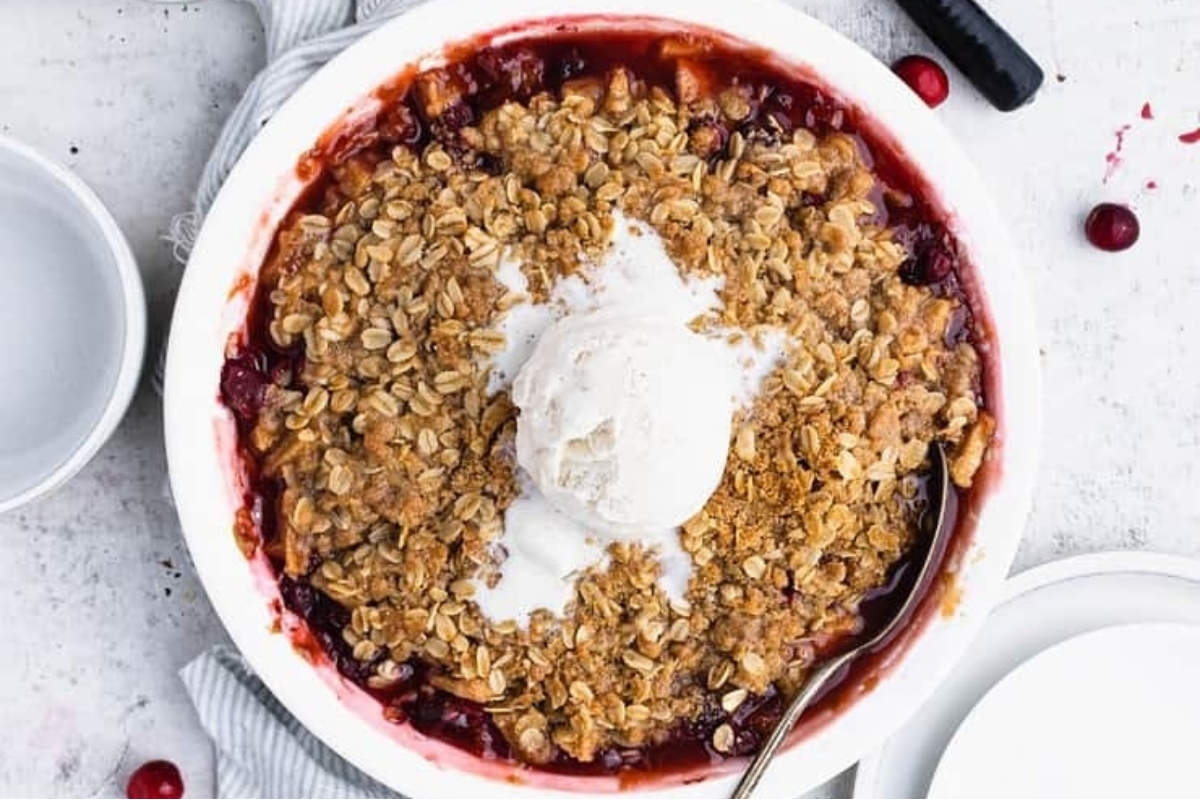 A country-style bowl of cranberry crisp with ice cream.