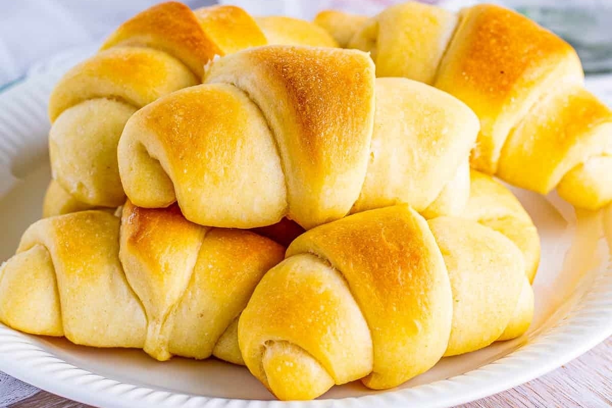 A plate with a bunch of croissants on it, perfect for enjoying with a bread basket.