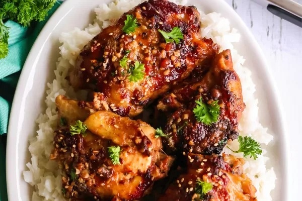 A white plate with chicken and rice on it.