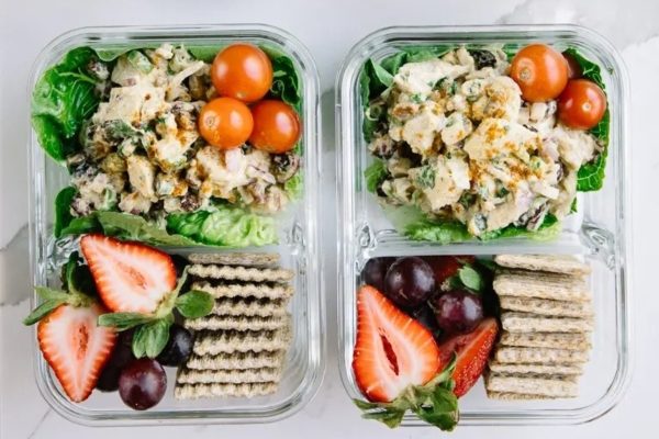 Two clear plastic containers with chicken salad and crackers.
