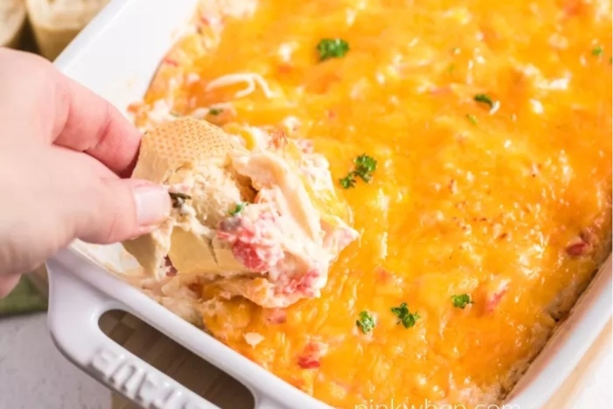 A person indulging in a Christmas party appetizer - a dish of cheesy dip.