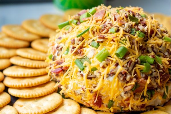 This description features a delicious bacon cheese ball with crackers and green onions. It's the perfect appetizer for any occasion.
