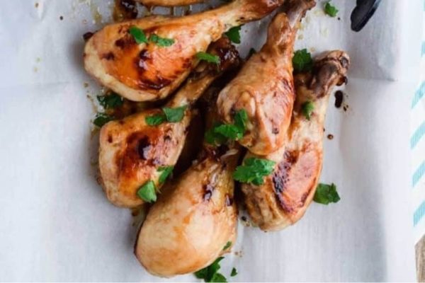 Grilled chicken legs on a sheet of paper.