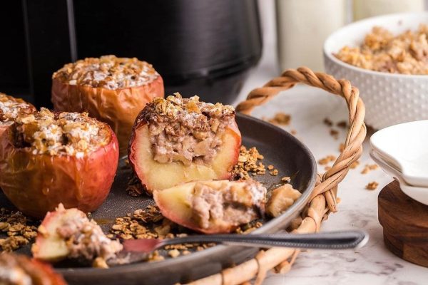 Apples with granola on a plate in front of a slow cooker.
