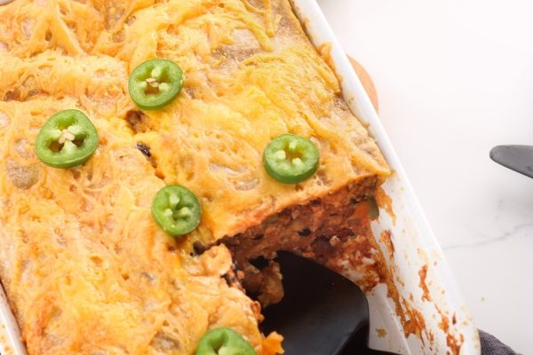 Mexican lasagna with jalapenos in a baking dish.