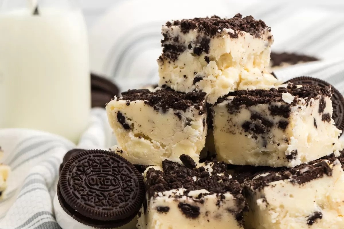 No Bake Oreo fudge stacked on top of a glass of milk.