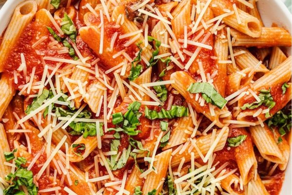 Penne Pasta Recipes 12 Delicious and creamy penne pasta served with a rich tomato sauce and topped with freshly grated parmesan cheese, all beautifully presented in a white bowl.
