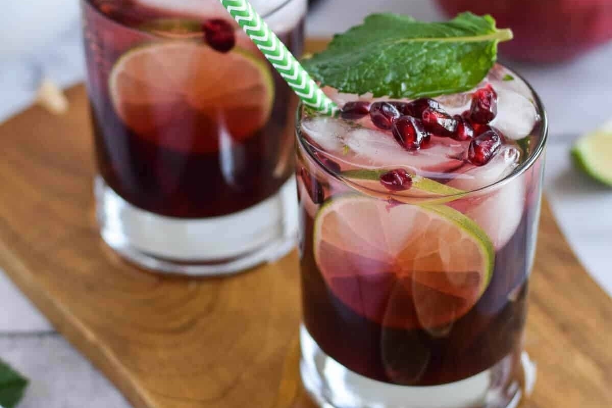 Two glasses with pomegranate juice and mint leaves, perfect for refreshing recipes.