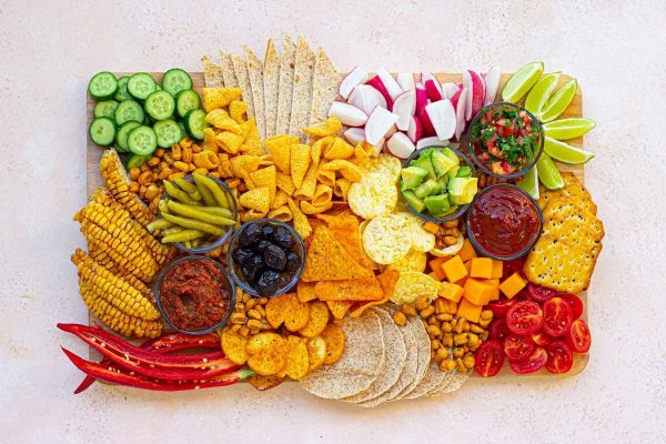 A tray of chips and vegetables on a white background.