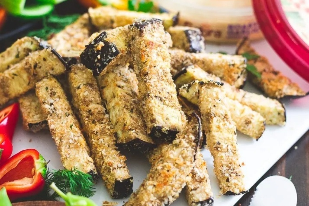 A plate of fried eggplant sticks with vegetables and dip, created using a flavorful fry recipe.