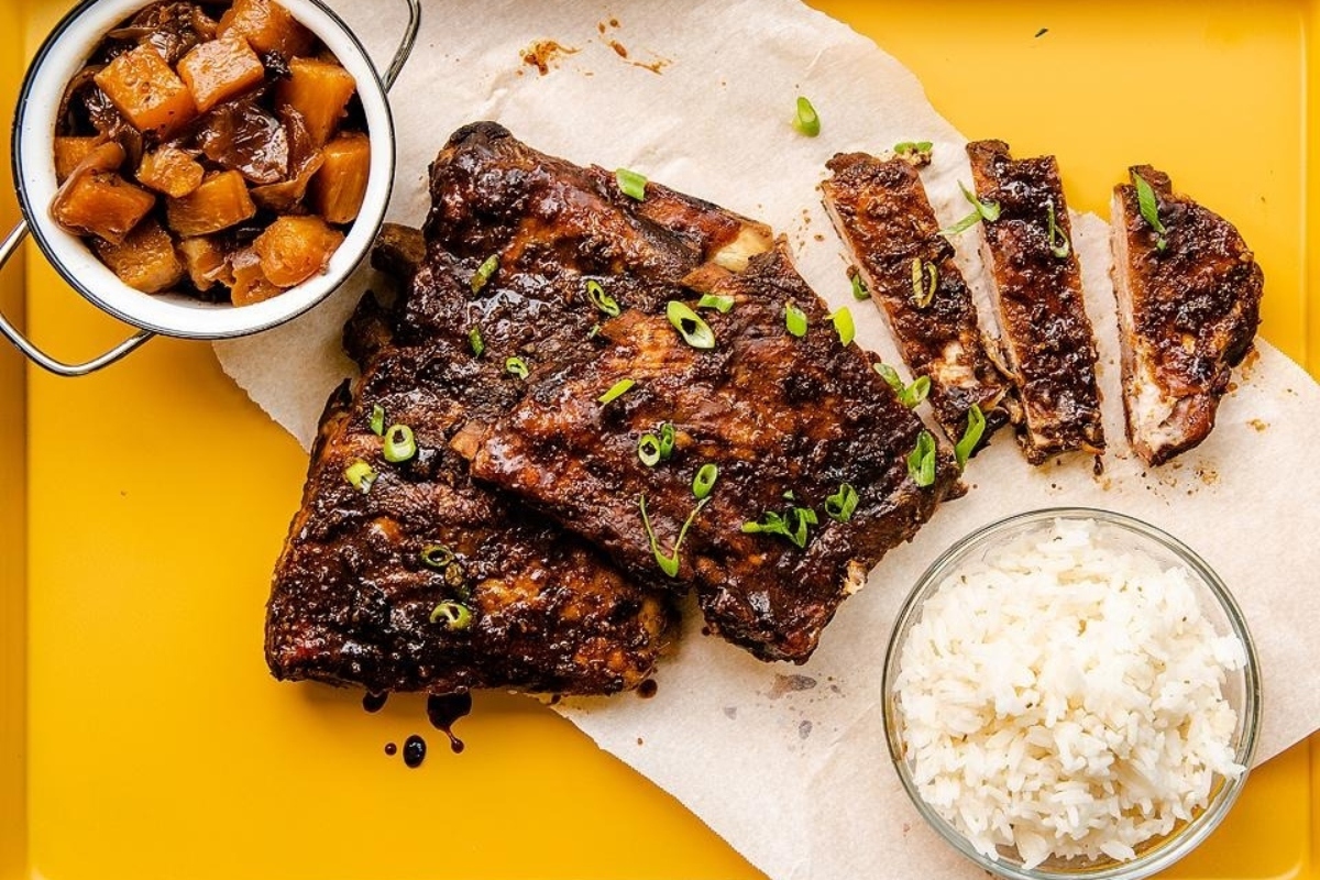 Ribs and rice on a yellow tray.