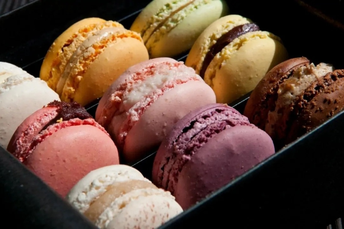 Elegant macarons in a black box on a table.
