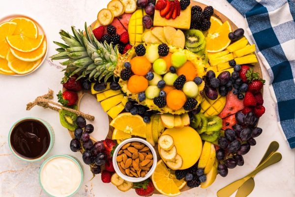 A Christmas fruit platter featuring a variety of fruits beautifully arranged on charcuterie boards.