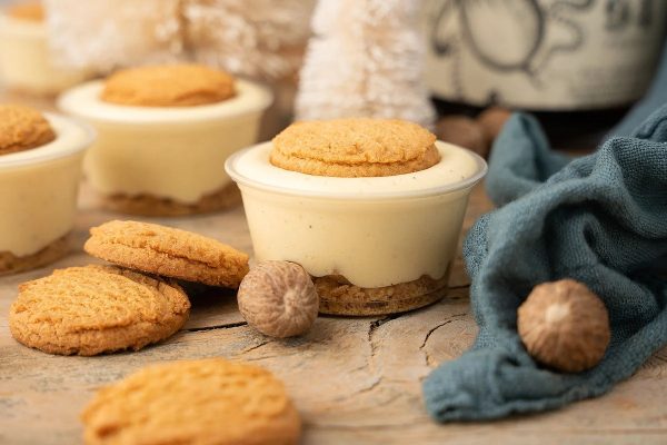 Mini cheesecakes with cookies on a wooden table, perfect for dessert recipes.